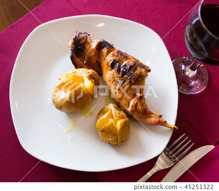 Baked in oven quarter of rabbit, served with pototoes at plate Baked in oven quarter of rabbit, served with pototoes at plate 45251322