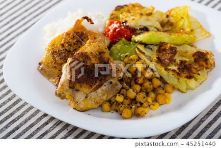 Chicken thighs with cabbage leaves in batter, cheakpea and rice at plate Chicken thighs with cabbage leaves in batter, cheakpea and rice at plate 45251440