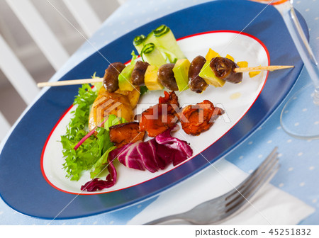 Fried chicken heart skewers with avocado and fried chanterelles served at plate 45251832