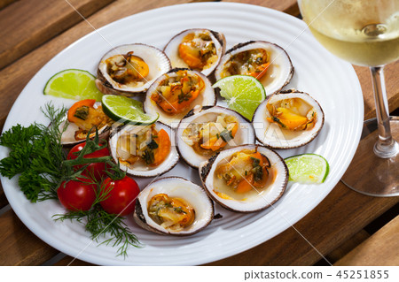 Deliciously baked dog with lemon, cherry tomatoes and greens at plate 45251855