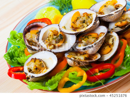 Baked dog cockles with vegetables 45251876
