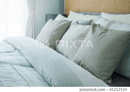 Closeup beige pillows on comfortable bed at home Closeup beige pillows on comfortable bed at home 45252534