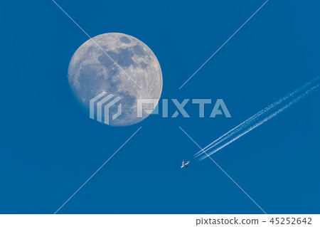 Full moon and flying plane with clear blue sky. 45252642