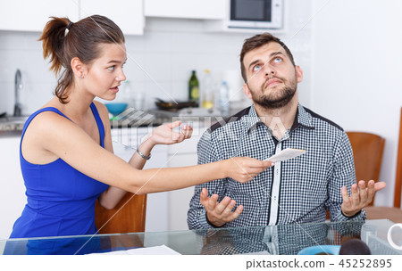 Upset young couple with financial bills having conflict in home Upset young couple with financial bills having conflict in home 45252895