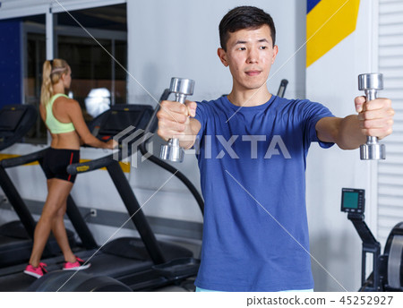 Man doing exercises with dumbbells 45252927