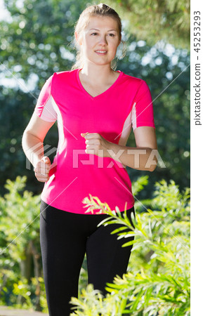 Female 20-30 years old is running around in pink T-shirt 45253293