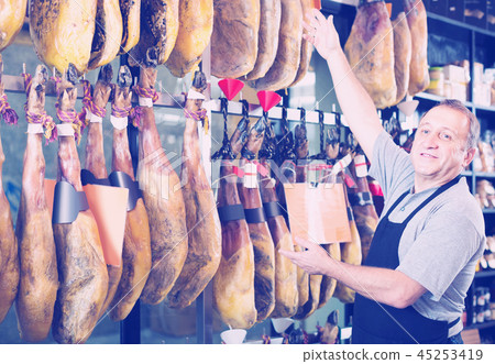 seller in deli shop with iberico and serrano jamon seller in deli shop with iberico and serrano jamon 45253419