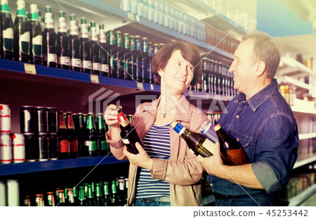 Portrait of an elderly couple buying a beer at the grocery store 45253442