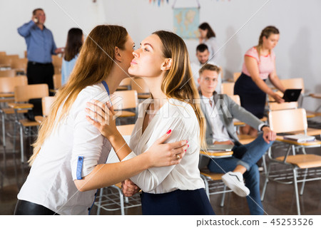 Two women kissing each other by meeting Two women kissing each other by meeting 45253526