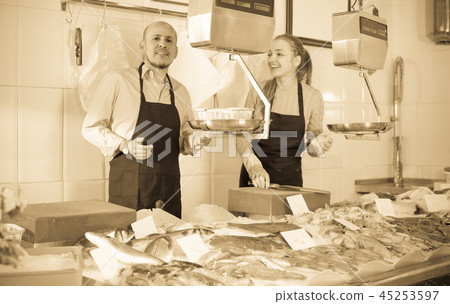 Two sellers in fish store . 45253597