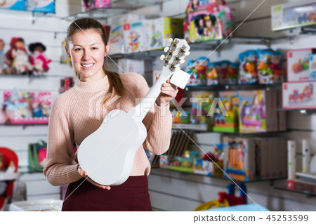 woman among children's toys with guitar 45253599