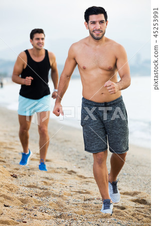 Two sportsmen jogging on beach Two sportsmen jogging on beach 45253991