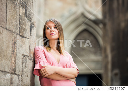 Young girl standing near brick wall at street in center of Barcelona 45254207