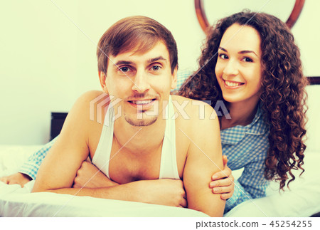 Young boyfriend and girlfriend smiling in home bed Young boyfriend and girlfriend smiling in home bed 45254255