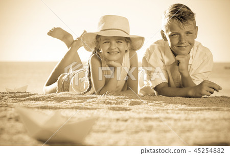 two kids lying beach 45254882