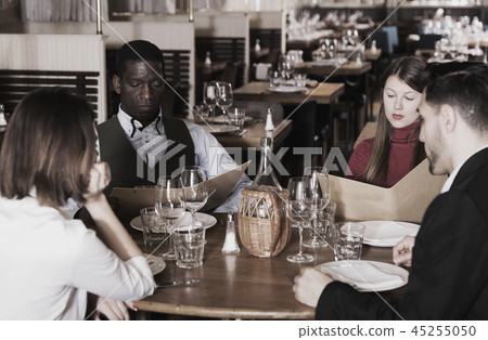 Group of people choosing dishes from menu 45255050