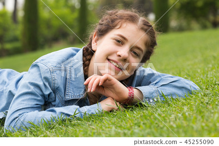 portrait of young female while lying in spring green garden 45255090