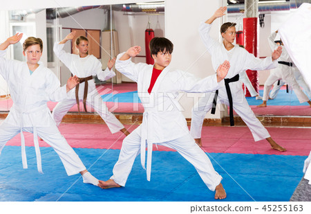 Kids in kimonos practicing effective karate techniques Kids in kimonos practicing effective karate techniques 45255163