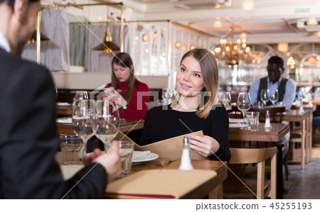 Girl with boyfriend choosing meal from menu Girl with boyfriend choosing meal from menu 45255193