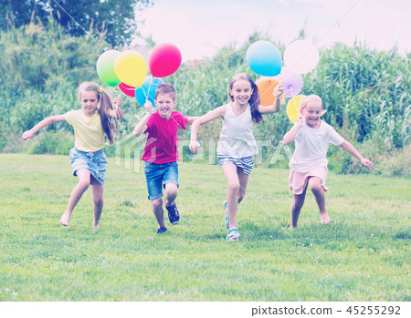 Children running with colorful balloons Children running with colorful balloons 45255292