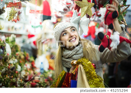 Girl choosing Christmas gifts outdoor. Girl choosing Christmas gifts outdoor. 45255294