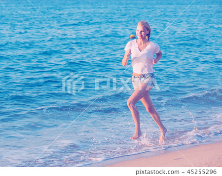 Female in white T-shirt is jogging 45255296