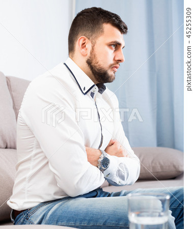 Man feeling distressed and lonely alone at home Man feeling distressed and lonely alone at home 45255309