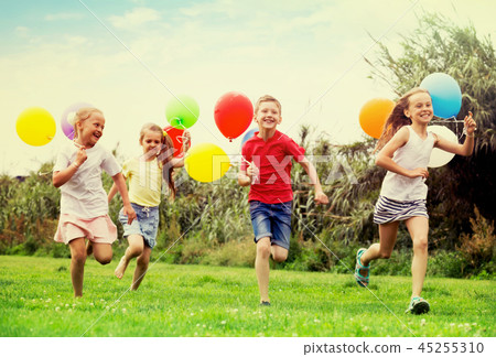 children running with air balloons in park . children running with air balloons in park . 45255310
