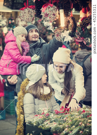 Family of four choosing decorations 45255311