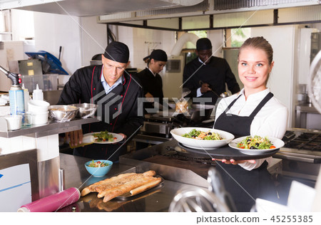Waitress with dishes in kitchen Waitress with dishes in kitchen 45255385