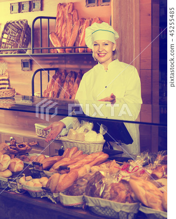 Bakery employee offering bread Bakery employee offering bread 45255485