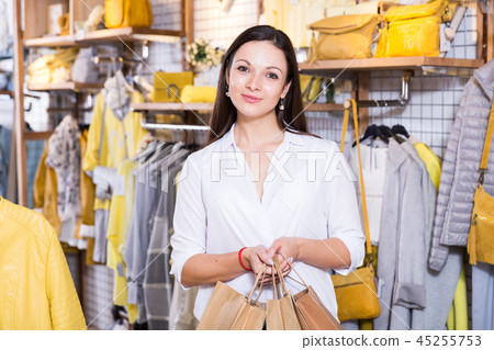Young woman customer with paper bags in clothes fashion shop Young woman customer with paper bags in clothes fashion shop 45255753