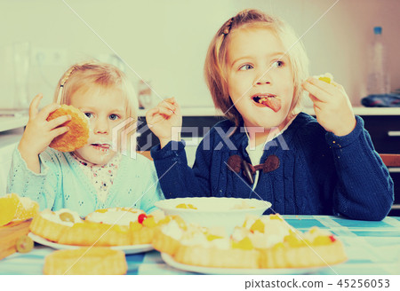 Two little girls with cream desserts Two little girls with cream desserts 45256053