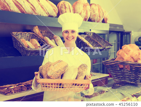 Woman offering bread in bakery 45256110