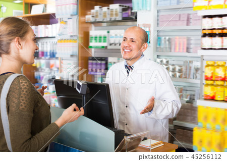 Pharmaceutist helping young girl in drugstore Pharmaceutist helping young girl in drugstore 45256112