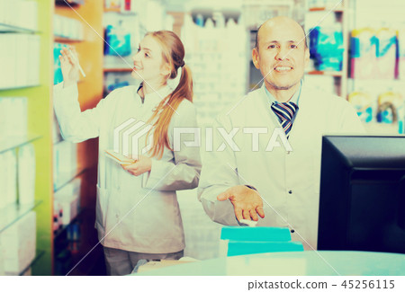 Pharmacist and assistant working at farmacy reception Pharmacist and assistant working at farmacy reception 45256115