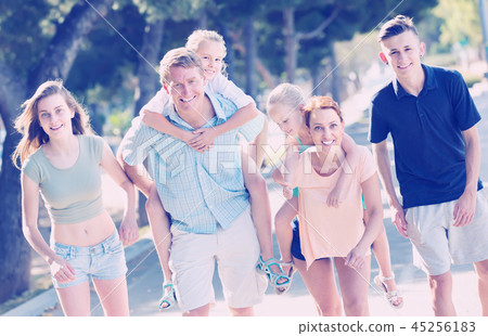 big family of six people walking with kids on parents back in su 45256183
