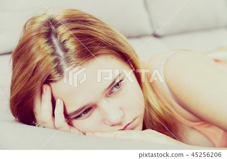sad female on cozy sofa at home 45256206