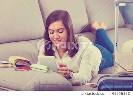 Woman booking online for holidays at home 45256358