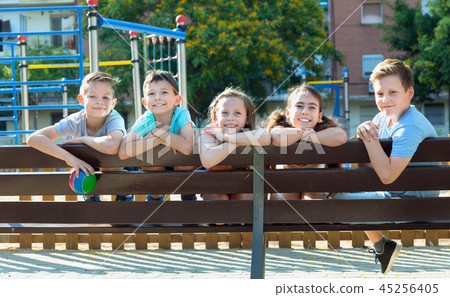 Five children sitting on a bench at the playground 45256405
