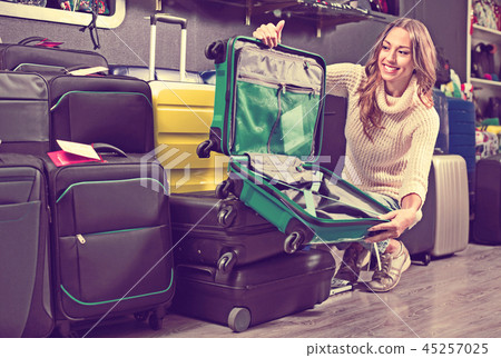 Female customer choosing travel suitcase Female customer choosing travel suitcase 45257025