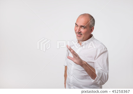 Mature hispanic man in white shirt showing a gesture like stop please, it is enough. Mature hispanic man in white shirt showing a gesture like stop please, it is enough. 45258367