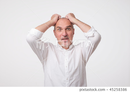 Elderly man in surprise grabs his head. Elderly man in surprise grabs his head. 45258386