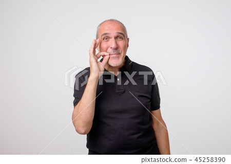 Keeping quiet and silence concept. Concept of mature amn zipping or closing his mouth Keeping quiet and silence concept. Concept of mature amn zipping or closing his mouth 45258390