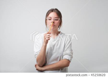 European girl in glasses thought with a pencil. European girl in glasses thought with a pencil. 45258620
