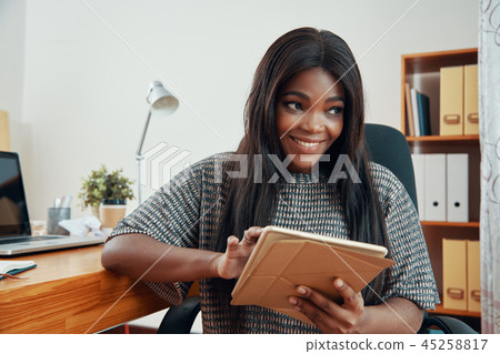 Smiling black woman with tablet in office 45258817