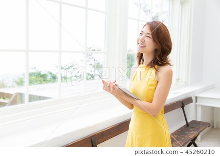 觀看一種片劑的婦女在屋子裡 觀看一種片劑的婦女在屋子裡 45260210