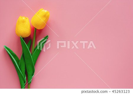 Artificial yellow tulips on pink background Artificial yellow tulips on pink background 45263123