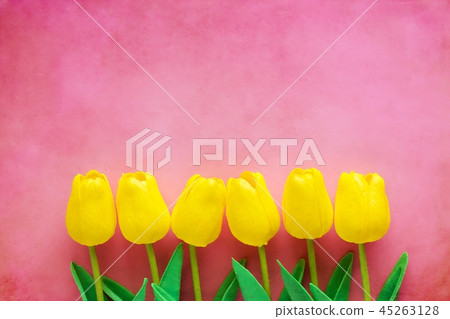 Artificial yellow tulips on pink background Artificial yellow tulips on pink background 45263128