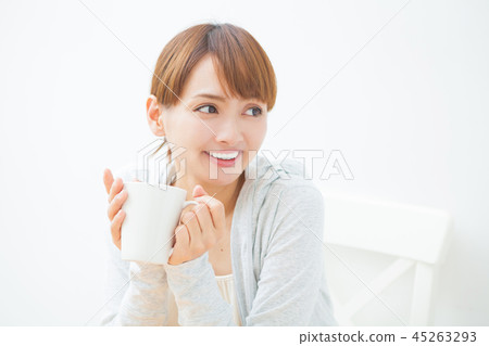 A woman drinking a hot drink A woman drinking a hot drink 45263293